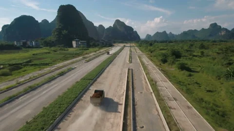 China development, drone flight of construction truck driving over dusty road Видео 67534642