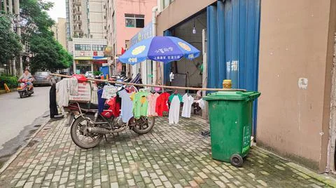 China, drying clothes on the street, a green trash can. Stock Photos