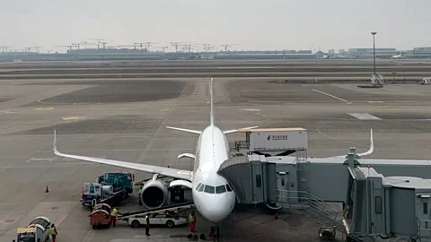 A China Eastern passenger airplane having its luggage offloaded at the gate at Stock Footage 331152862