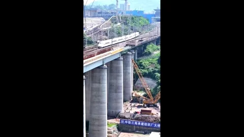 China: Engineers build rail bridge inches from passing trains in Chongqin... Video stock 336668278