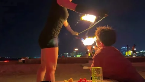 China: Fire dancer lights cigarette during performance in Hainan, China Stock Footage 331073445