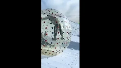 China: Inflatable snowball ride sends two Chinese visitors rolling down s... Stock Footage 327690819