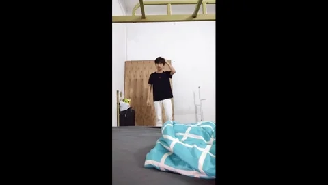 China: Man accidentally bumps head on bunk bed while setting up camera in... Stock Footage 335136189
