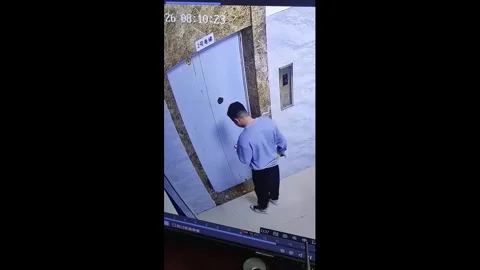 China: Man drops phone into elevator gap in Guizhou, China 库存影片 332211542