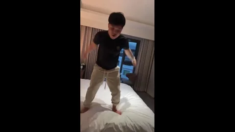 China: Man falls off bed while attempting backflip in Chongqing, China Stock Footage 333521198