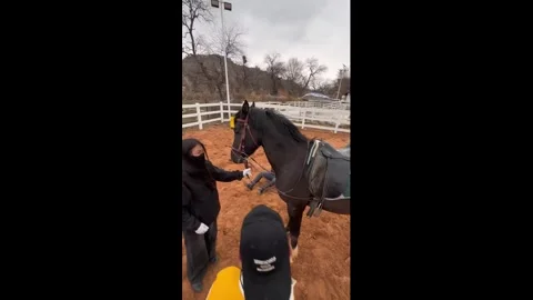 China: Man falls while attempting to mount horse in Gansu, China Stock Footage 333452663