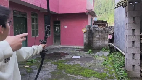 China: Man startled after arrow bounces back during archery attempt in Ch... Stock Footage 334026684