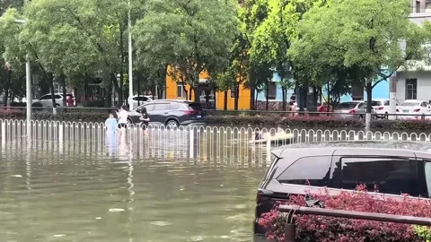 China: Pedestrian slips into floodwater while avoiding flooded road in Li... Stock Footage 340345737