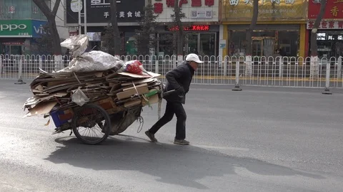 China poverty and inequality - man pulls cardboard through streets Xining Stock Footage