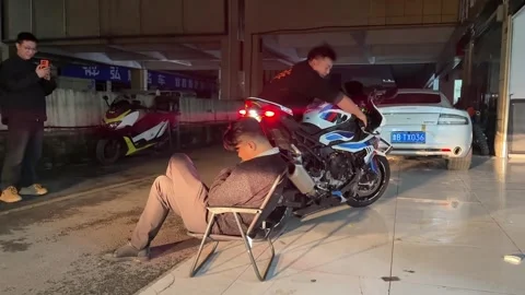 China: Sleeping man startled awake by motorcycle rev in Hubei, China Stock Footage 331944159