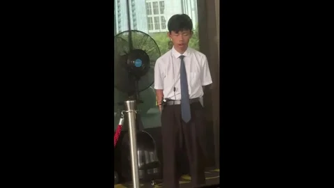 China: Sleepy security guard nearly loses balance while dozing on his fee... Stock Footage 344970129