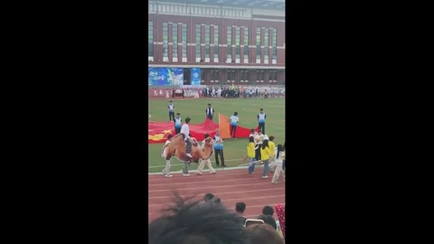 China: Students march with giant camel cutout during school sports event ... Stock Footage 336771941