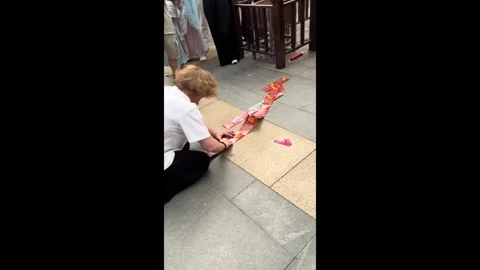 China: Tourist does his scratch cards in front of Buddha statue for good ... Stock Footage 320663304