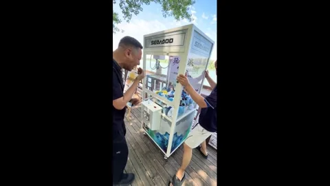 China: Two men cheat claw machine by tilting it to win prize in Liaoning,... Stock Footage 336571136