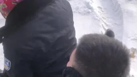 China: Two men enjoy playful tire sledding in heavy snow in Heilongjiang,... Stock Footage 320653128