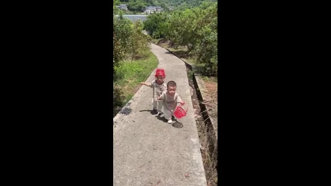 China: Two toddlers fall while walking hand-in-hand in Sichuan, China Stock Footage 335455378