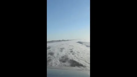 China: Wind-driven snow sweeps across roadway in wave-like patterns in Ka... Stock Footage 327635362