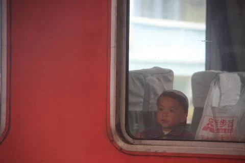 A Chinese Boy inside the train. Looking the window. China Railway Trip. 12th Foto stock