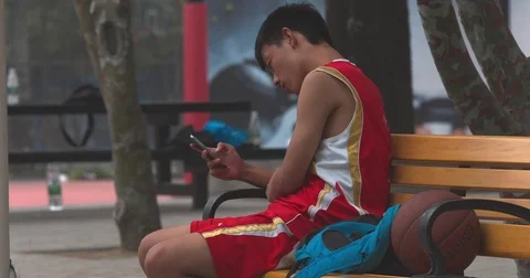 Chinese boy texts on cellphone Stock Footage 71865974