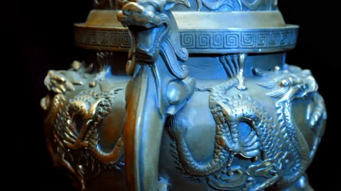 Chinese bronze cup with many embossed dragons rotates on a black background Stock Footage 121593773