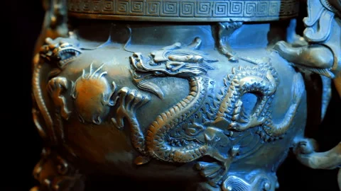 Chinese bronze cup with many embossed dragons rotates on a black background Stock Footage 121594405