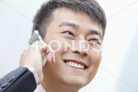 Chinese businessman talking on cell phone Stock Photos