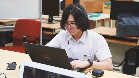 Chinese Computer Engineering student working on his coding project on his laptop Vidéo 107372286