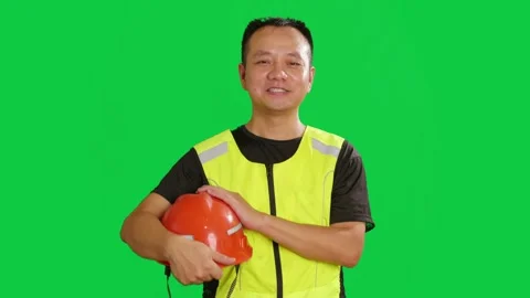 Chinese construction worker holds red safety hard hat and smiles at camera. Stock Footage 343606330