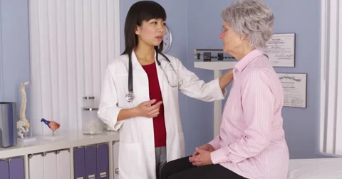 Chinese doctor talking to elderly patient Stock Footage