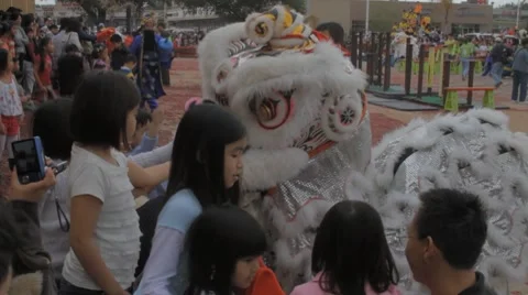 Chinese Dragon Dance Performer Playing with Children During Chinese New Years Stock Footage 8691250