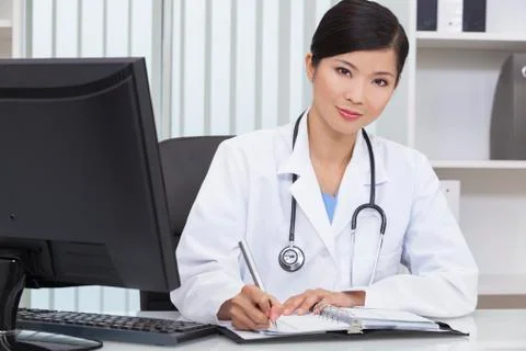 Chinese female woman hospital doctor writing in office Stock Photos