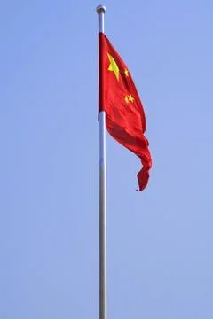 The Chinese Flag Flapping Against A Solid Blue Sky Stock Photos