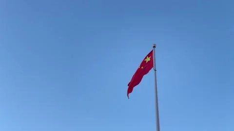 Chinese flag waving under clear blue sky Stock Footage 307570646