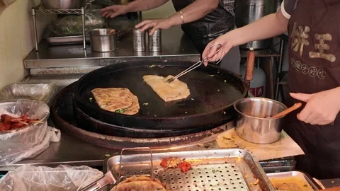 Chinese Flatbread Cooks on a Large Round Griddle in Shanghai Stock Footage 340176634