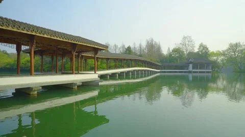 Chinese garden stone bridge with reflection, and water bird flying over Stock Footage 312987071