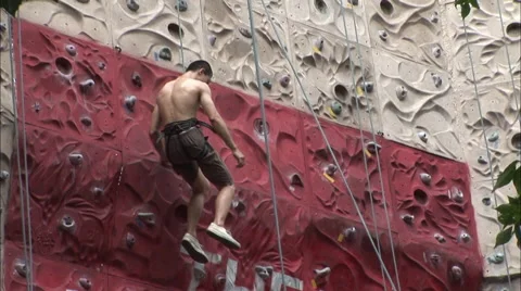 Chinese man abseils down climbing wall Stock Footage 58613976