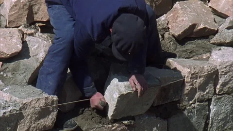 Chinese man carefully sets a stone in place on the Great Wall of China Stock Footage 78506871