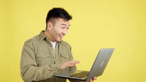 Chinese man celebrating while looking at the laptop Stock Footage 236811299