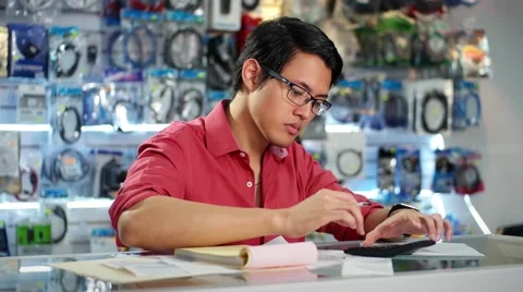 Chinese Man Working In Computer Shop Checking Bills And Invoices Stock Footage 48780511