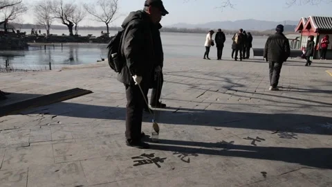 A Chinese Man is Writing Chinese Script on the ground  , Hangzhou, China Stock Footage 144238829