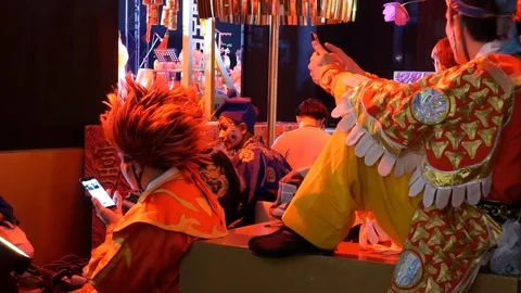 Chinese opera performers using mobile phones Stock Footage 122145126