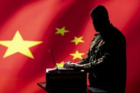 Chinese operative coding on laptop, developing program able to deploy bots 스톡 사진