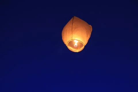 Chinese paper lantern flies into the blue sky. Stock Photos