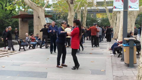 Chinese people dancing in a park with a pan up to trees - SloMo - 24fps Stock Footage 192465863