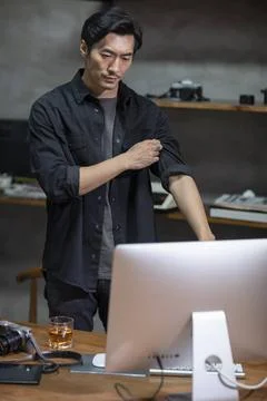  Chinese photographer using computer in studio Beijing China Copyright: xL... Stock Photos