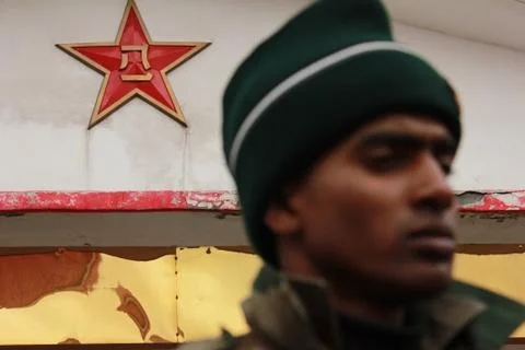 The Chinese PLA logo seen while indian solder is out of focus and stands guard Stock Photos