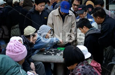 Chinese playing a game in NYC Stock Photos
