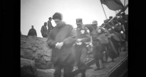 Chinese prisoners walk along Inchon pier area to board landing craft Stock Footage