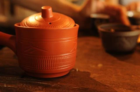 Chinese red clay teapot with ornament on wooden table Stock Photos
