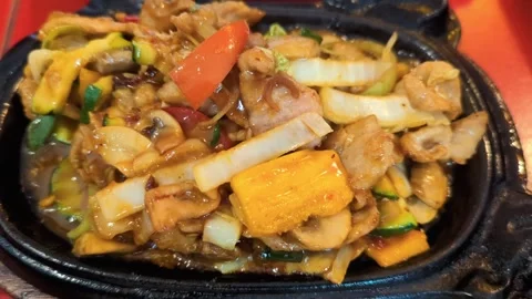 Chinese style chicken fried with vegetables and served on black iron, hot plate. Stock Footage 304854491